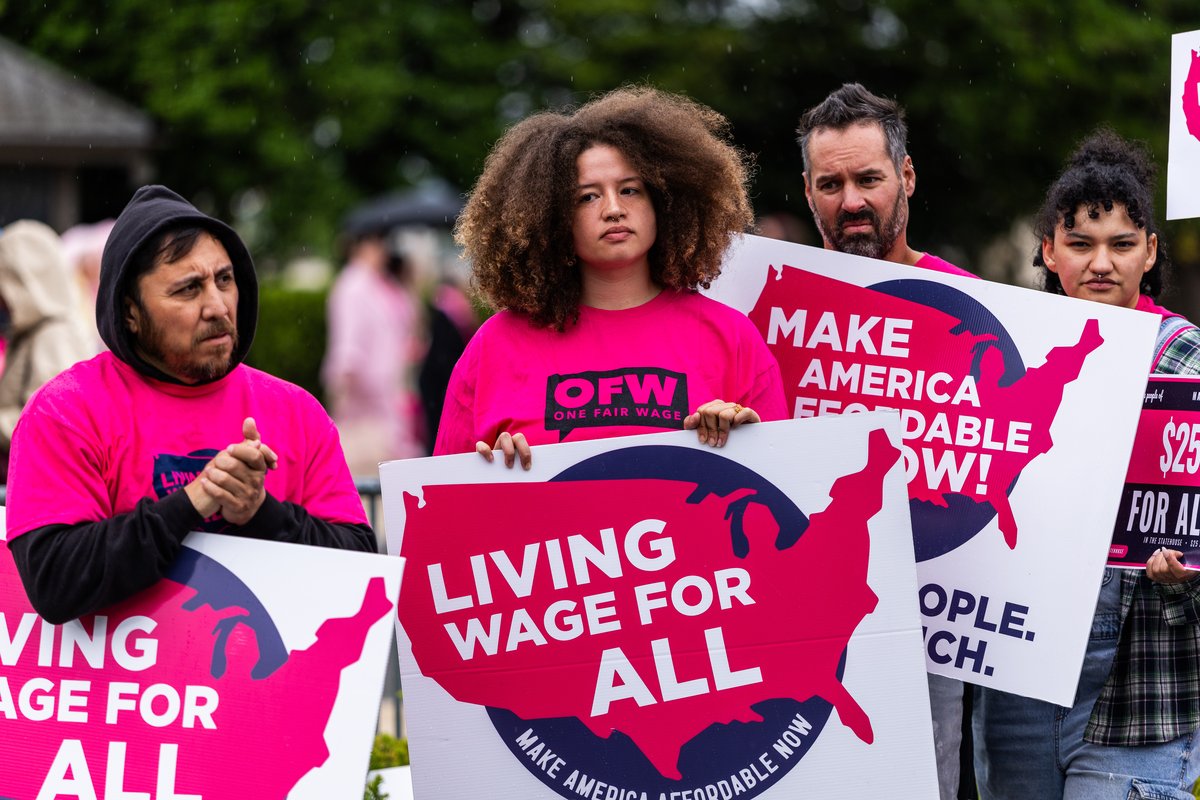 Workers and organizers from the Living Wage For All coalition holding signs at the U.S. Capitol